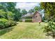 Lush backyard with a brick home featuring a screened porch and mature trees at 1503 Jack White Dr, Rock Hill, SC 29732