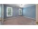Bright bedroom features two windows with natural light, light blue walls, neutral carpet, and ceiling fan at 1503 Jack White Dr, Rock Hill, SC 29732