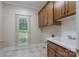 Functional laundry room with cabinetry, sink, and a view of the backyard from the window at 1503 Jack White Dr, Rock Hill, SC 29732