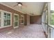 A covered porch with brick floor, brick walls, two ceiling fans and framed screens for bug protection at 1503 Jack White Dr, Rock Hill, SC 29732