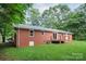 A well-maintained brick house features a wooden deck and spacious green backyard at 1538 Hilltop Dr, Shelby, NC 28150