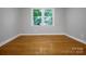A sunlit bedroom features gleaming hardwood floors and a view of lush greenery at 1538 Hilltop Dr, Shelby, NC 28150