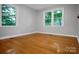 A sunlit bedroom features gleaming hardwood floors and a view of lush greenery at 1538 Hilltop Dr, Shelby, NC 28150