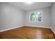 A sunlit bedroom features gleaming hardwood floors and a view of lush greenery at 1538 Hilltop Dr, Shelby, NC 28150