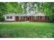 Charming brick home with a well-manicured lawn, inviting entrance and beautiful, mature trees at 1538 Hilltop Dr, Shelby, NC 28150