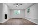 Modern, minimalist living room with brick fireplace, vinyl floors, and natural light at 1538 Hilltop Dr, Shelby, NC 28150
