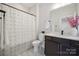 Bright bathroom with a stylish vanity, modern fixtures, decorative pink flowers, and a patterned shower curtain at 19012 Beecher Commons Dr, Huntersville, NC 28078