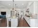 Spacious kitchen island with sink and seating, flowing into the open floor plan with modern white cabinetry at 19012 Beecher Commons Dr, Huntersville, NC 28078