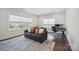 Inviting living room with hardwood floors, a comfortable couch, a large window, and a dedicated workspace at 19012 Beecher Commons Dr, Huntersville, NC 28078