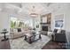 Bright living room features coffered ceilings, stone fireplace, and access to a covered outdoor area at 19012 Beecher Commons Dr, Huntersville, NC 28078