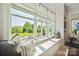 Cozy window seat with pillows offers a view of the landscaped backyard and outdoor seating area at 19012 Beecher Commons Dr, Huntersville, NC 28078