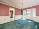 Formal dining room with an adjacent kitchen entrance, featuring classic wainscoting, a chandelier, and bay windows at 2912 Peachwood Ct, Fort Mill, SC 29715