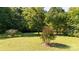 Beautifully maintained backyard with lush lawn, mature trees, and manicured garden beds at 2949 Glenstone Dr, Rock Hill, SC 29730