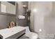 Modern half bathroom with stylish fixtures, a gray vanity and decorative shelving at 4520 Buck Skin Ct, Fort Mill, SC 29707