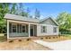 Charming front exterior with gray siding, a covered porch, and well-maintained landscaping at 671 Sylvan Sw St, Concord, NC 28025
