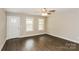Bright living room featuring two windows, a ceiling fan, and a hardwood floor for a cozy and inviting atmosphere at 671 Sylvan Sw St, Concord, NC 28025