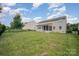 View of the back of the home with a big lush backyard with an enclosed porch at 7362 Waterwheel Sw St, Concord, NC 28025