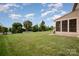 Expansive backyard with lush green grass, a partial fence, and a screened-in back porch at 7362 Waterwheel Sw St, Concord, NC 28025
