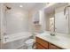 Bright bathroom featuring a tub-shower, vanity with sink, tile floor, and a view to the hallway at 7362 Waterwheel Sw St, Concord, NC 28025