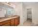 Bathroom with a dual sink vanity, tiled floors, and separate walk-in closet at 7362 Waterwheel Sw St, Concord, NC 28025