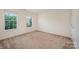 Carpeted bedroom with two bright windows at 7362 Waterwheel Sw St, Concord, NC 28025