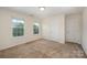 Bedroom with neutral walls, plush carpet, bright windows, and two doors at 7362 Waterwheel Sw St, Concord, NC 28025