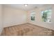 Bedroom with neutral walls, plush carpet, and a window offering natural light and neighborhood views at 7362 Waterwheel Sw St, Concord, NC 28025