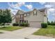 View of the house showcasing the driveway, landscaping and the combination of brick and light beige vinyl siding at 7362 Waterwheel Sw St, Concord, NC 28025