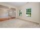 Bright living room with large windows, neutral carpet, and views to the entry foyer at 7362 Waterwheel Sw St, Concord, NC 28025