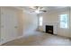 Cozy bedroom featuring a fireplace, neutral carpet, and ample natural light from two windows at 810 Lakeview Dr, Pineville, NC 28134