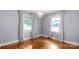 Cozy bedroom with hardwood floors, decorative chandelier, and large windows offering ample natural light and pleasant views at 810 Lakeview Dr, Pineville, NC 28134