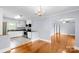 Open kitchen with white cabinets, stainless steel appliances, and tile floors; adjacent to a living area with hardwood floors at 810 Lakeview Dr, Pineville, NC 28134