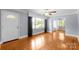 Bright living room featuring hardwood floors, large windows, and a charming front door with a decorative glass insert at 810 Lakeview Dr, Pineville, NC 28134