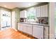 Well-lit kitchen featuring white cabinets, granite countertops, stainless steel sink and adjacent laundry room at 1274 Winding Path Rd, Clover, SC 29710