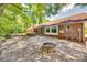 Spacious backyard featuring a stone patio, brick home exterior, and lush greenery at 1388 Aragon Beach Rd, Rock Hill, SC 29732