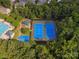 Overhead shot of community amenities including a pool, playground, tennis courts, and basketball court surrounded by mature trees at 13930 Daltrey Ln, Charlotte, NC 28277