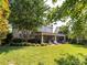 A spacious backyard features a covered patio with lounge furniture, perfect for outdoor living at 13930 Daltrey Ln, Charlotte, NC 28277