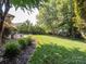 Serene backyard with lush green lawn, mature trees, and a cozy lounge area, perfect for relaxation at 13930 Daltrey Ln, Charlotte, NC 28277