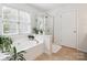 Bathroom showcasing a soaking tub, shower, and ample natural light from the large window at 13930 Daltrey Ln, Charlotte, NC 28277