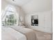 Light and airy bedroom with a window view and a built-in entertainment center at 13930 Daltrey Ln, Charlotte, NC 28277