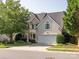Traditional two-story home with a well-manicured lawn and a two-car attached garage at 13930 Daltrey Ln, Charlotte, NC 28277