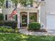 Charming home featuring a covered front porch with an American flag and lush landscaping at 13930 Daltrey Ln, Charlotte, NC 28277