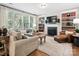 Cozy living room with a fireplace, built-in bookshelves, and large windows at 13930 Daltrey Ln, Charlotte, NC 28277