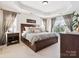 Spacious main bedroom featuring a large bed, tray ceiling, and ample natural light from the windows at 13930 Daltrey Ln, Charlotte, NC 28277