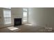 Spacious living room with a cozy fireplace, neutral carpet, and sun-filled windows providing natural light at 162 Autumn Falls Dr, Lake Wylie, SC 29710