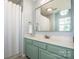 Bathroom with a wide mirror over a blue-green vanity and a shower with a white curtain at 17406 Tuscany Ln, Cornelius, NC 28031