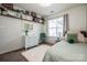 Bright bedroom featuring a decorative shelf, a window, a desk, and a cozy bed with pastel bedding at 17406 Tuscany Ln, Cornelius, NC 28031