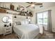 Bright bedroom featuring a decorative shelf display, a ceiling fan, and a large window for natural light at 17406 Tuscany Ln, Cornelius, NC 28031