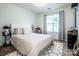 A calm, bright bedroom showcases a cozy bed with decorative pillows, a shaggy rug, and soft, natural light at 17406 Tuscany Ln, Cornelius, NC 28031
