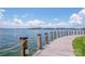 Scenic waterfront view featuring a wooden boardwalk, blue water, and a clear sky at 17406 Tuscany Ln, Cornelius, NC 28031